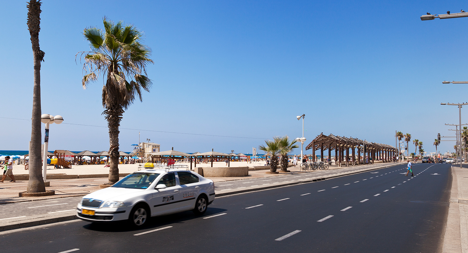 מונית נוסעת בכביש סמוך לטיילת